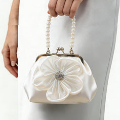 White satin evening bag with floral and rhinestone embellishments.